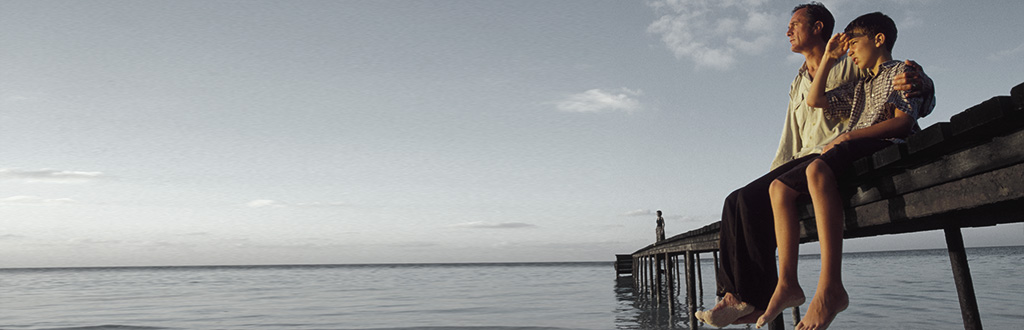 Vater und Sohn blicken auf das Meer